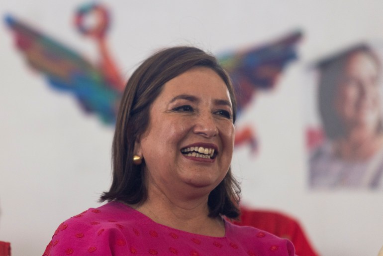 Xochitl Galvez smiles. Behind her are illustrations on a wall.