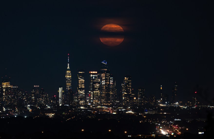 Flower moon rises over the high-rise buildings New York City.
