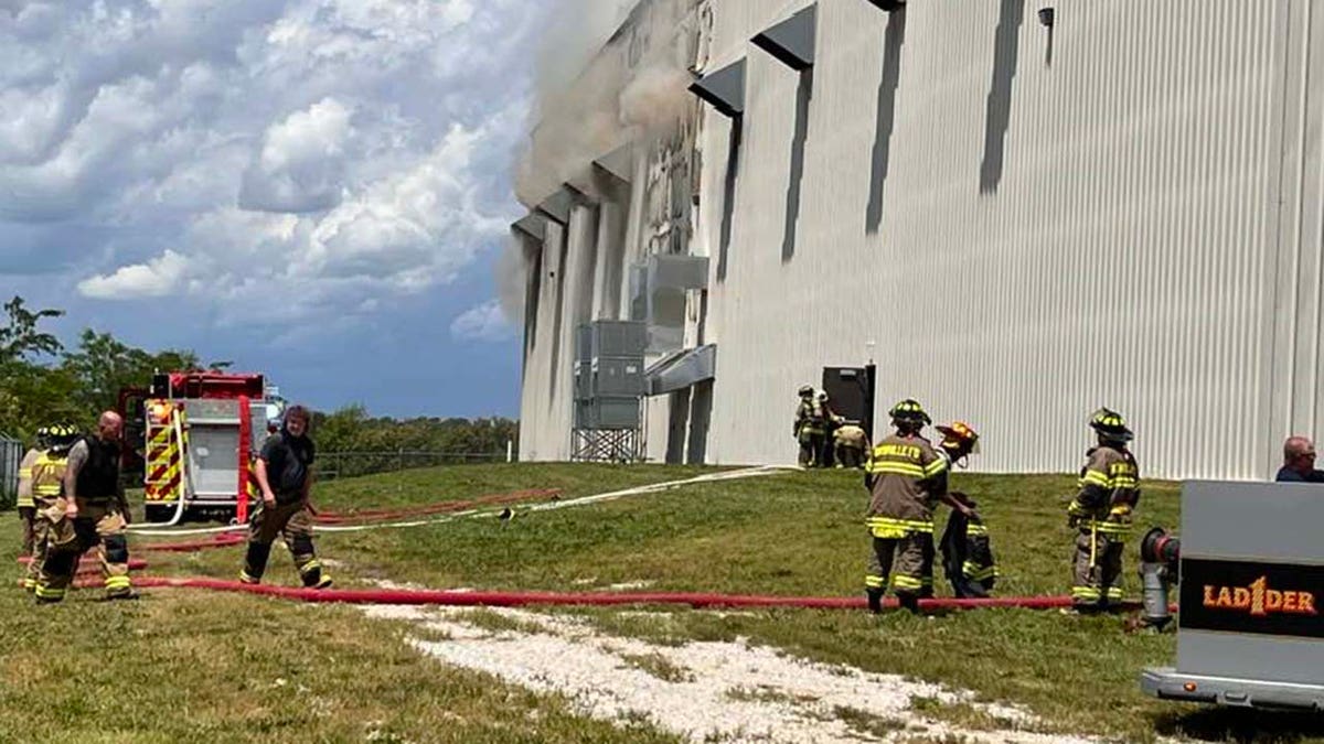 Wide shot of firefighters outside warehouse