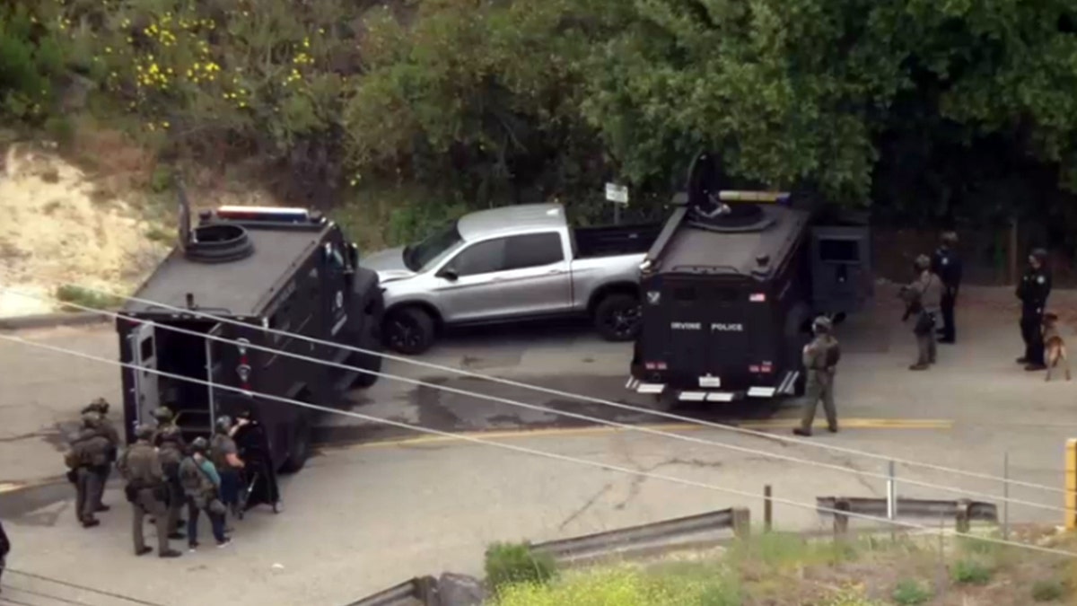 Silver pickup truck barricaded by police vehicles