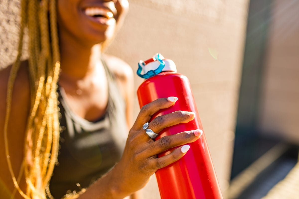 evie ring being worn by woman holding water bottle
