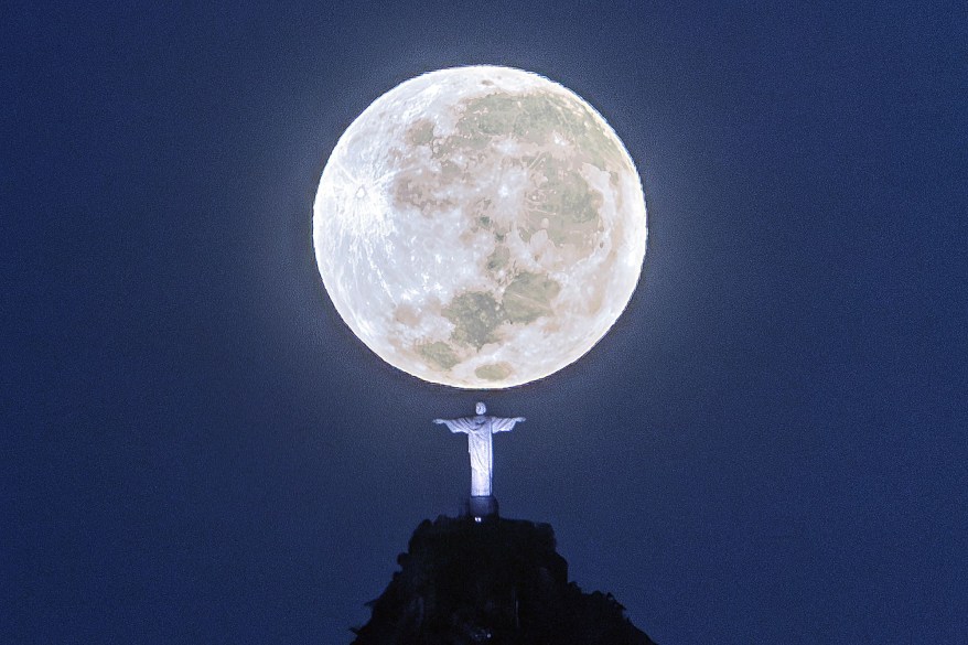 Moon sets behind the Christ the Redeemer monument in Rio de Janeiro, Brazil.