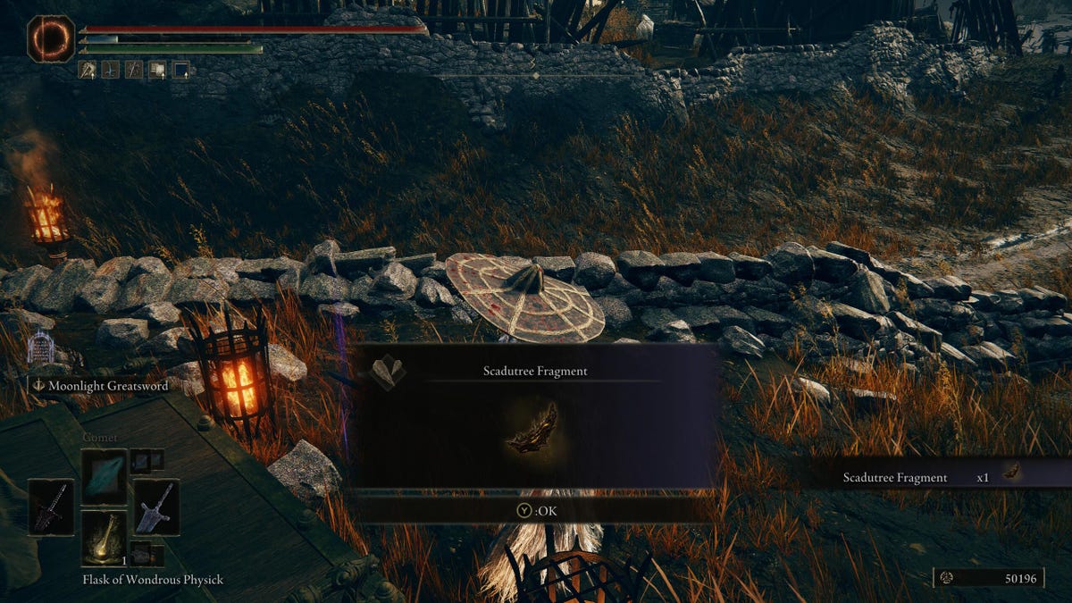 A game character standing in front of torches and getting an item.