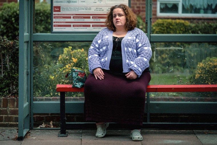 Martha sits at a bus stop