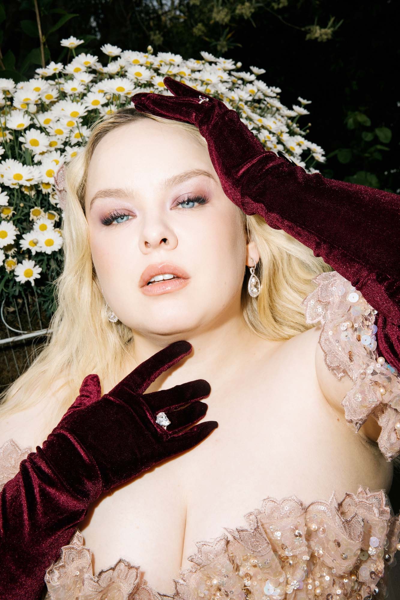 Image may contain Face Head Person Photography Portrait Clothing Glove Blonde Hair Daisy Flower Plant and Adult