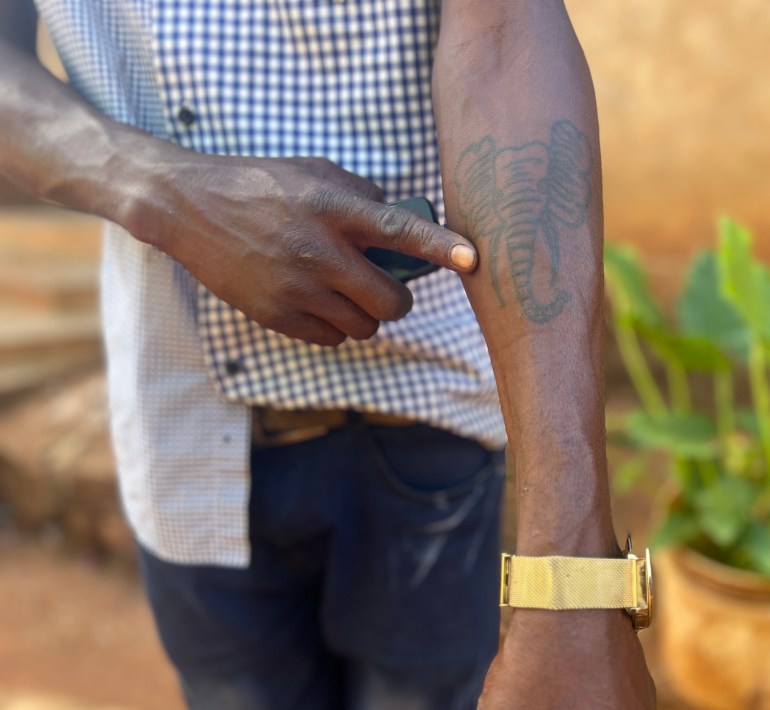 A man shows a tattoo of the elephant that killed his father