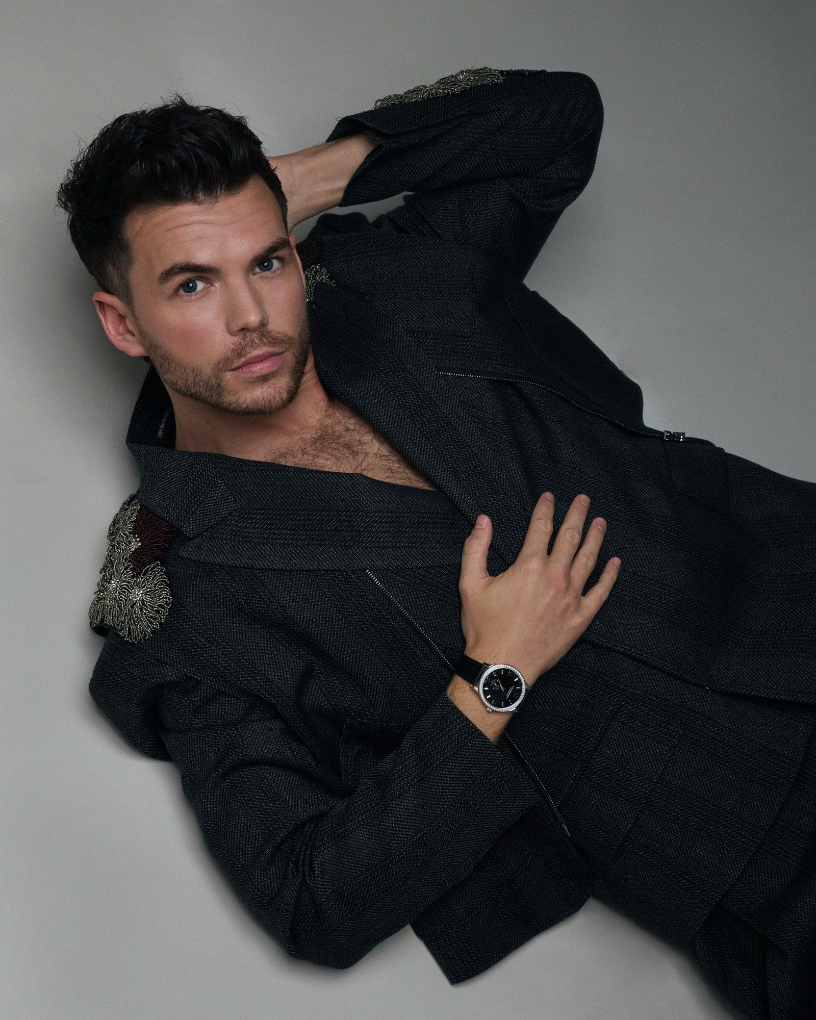 Image may contain Clothing Formal Wear Suit Blazer Coat Jacket Wristwatch Adult Person Face Head and Photography