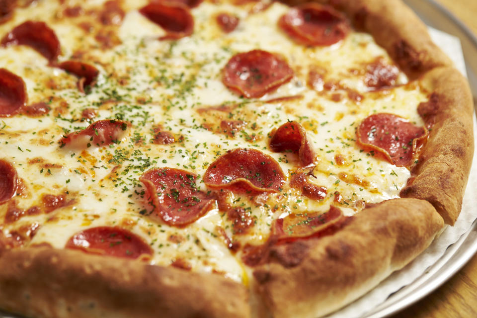 A close-up of a pepperoni pizza with melted cheese and sprinkled herbs