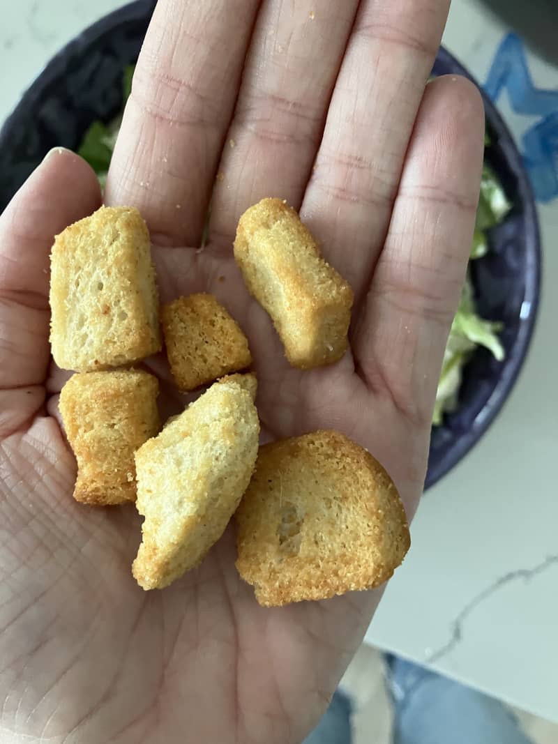 New York Bakery Texas Toast Garlic and Butter Croutons held in a hand.