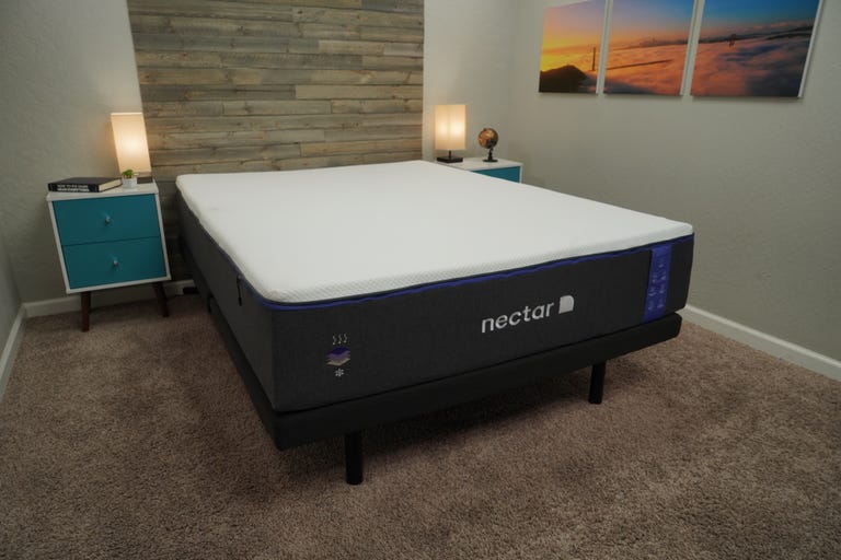 The Nectar Premier mattress with a blue nightstand next to it.