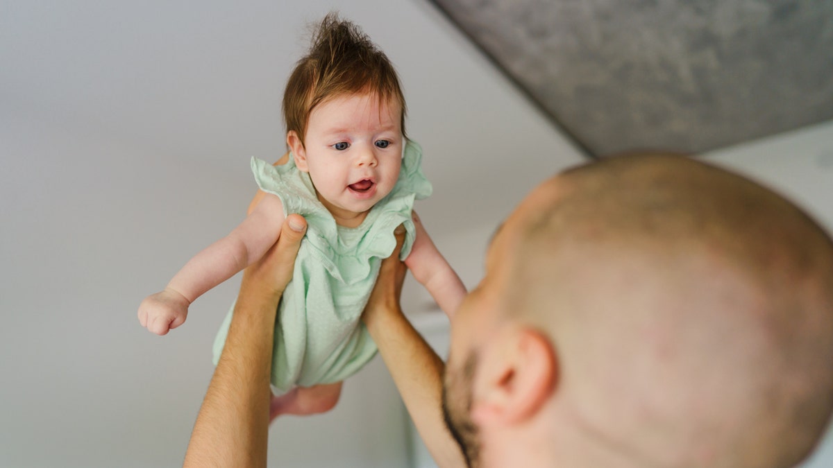 Father throwing baby