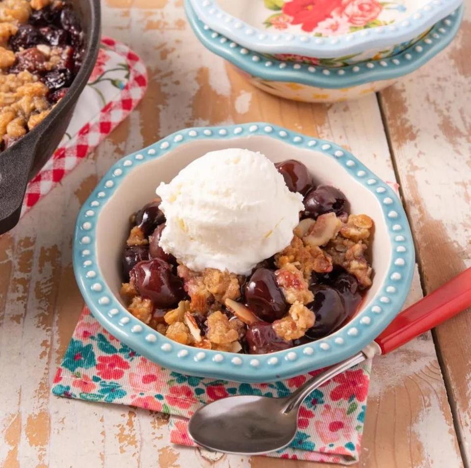 cherry crisp in bowl with scoop of vanilla ice cream