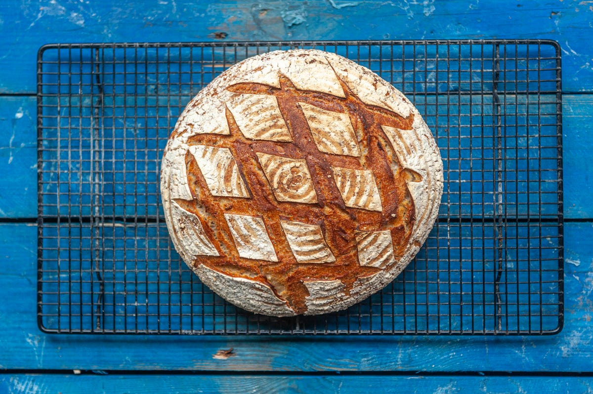 A loaf of sourdough sitting on a blue table