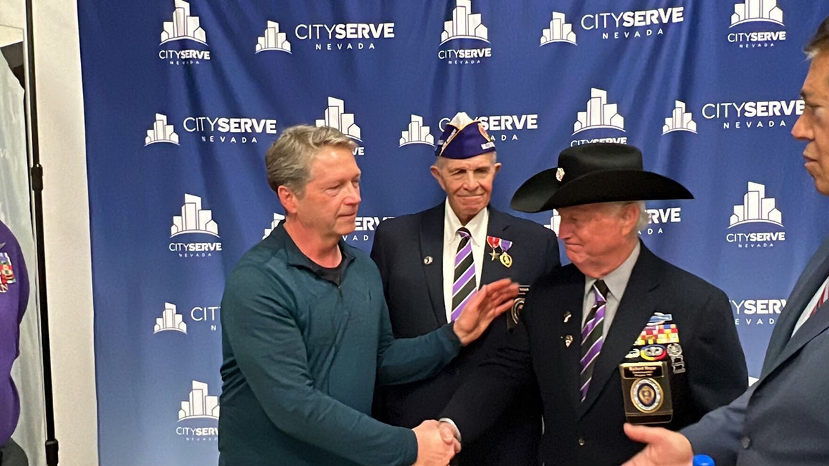 man shaking hands with veterans