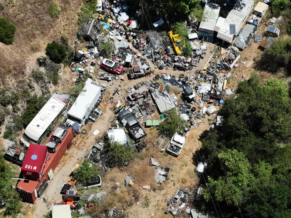 An aerial view of a property littered with objects and vehicles.