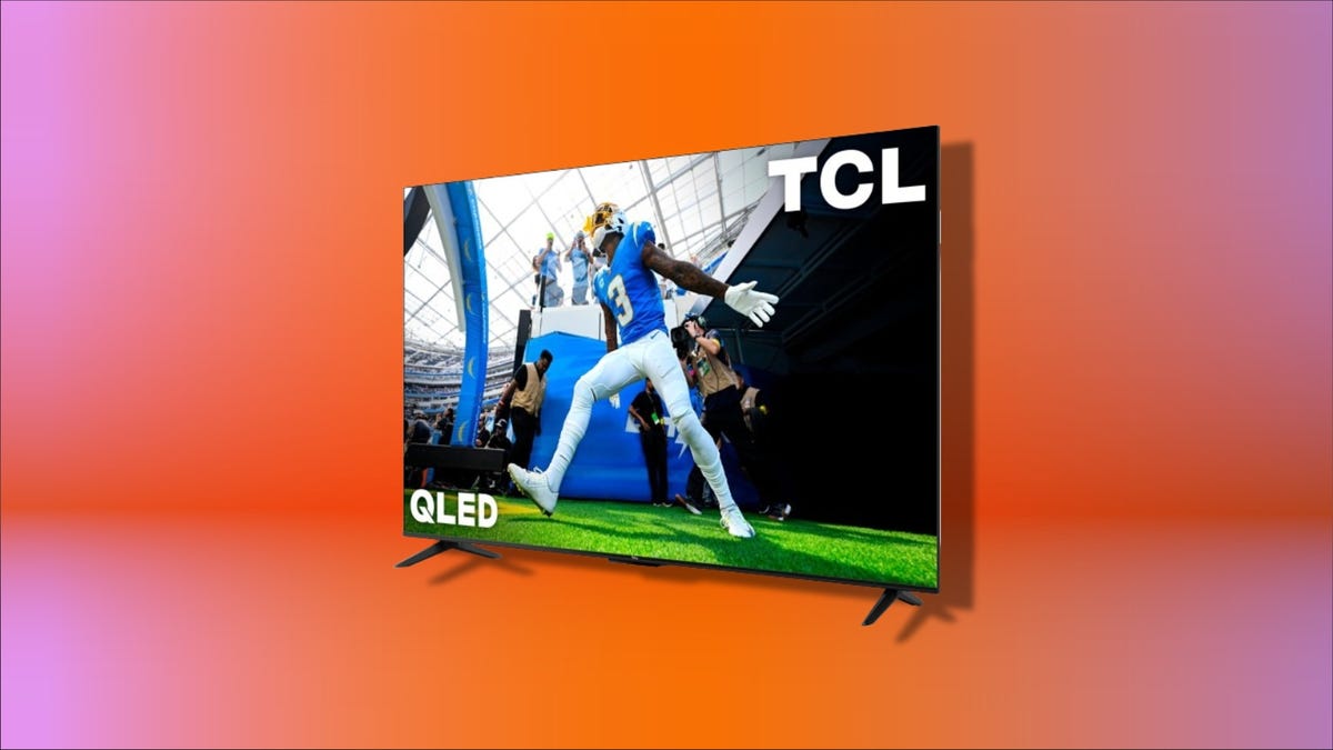 TCL QLED TV on display against a red gradient background.