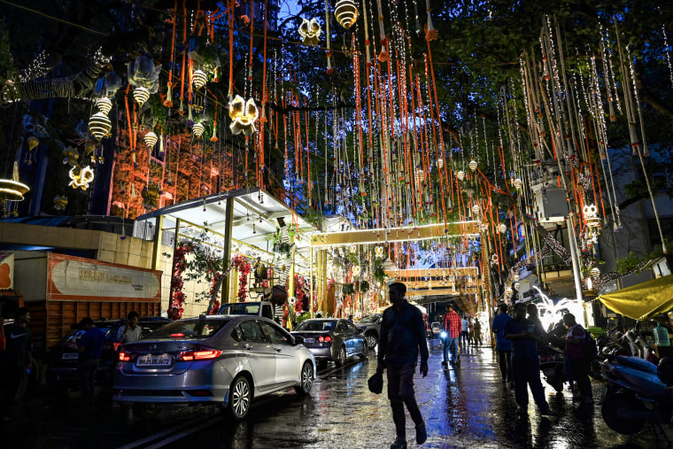 People walk past the Antilia mansion, house of billionaire Mukesh Ambani decorated ahead of his son Anant Ambani's wedding, in Mumbai on July 9, 2024.