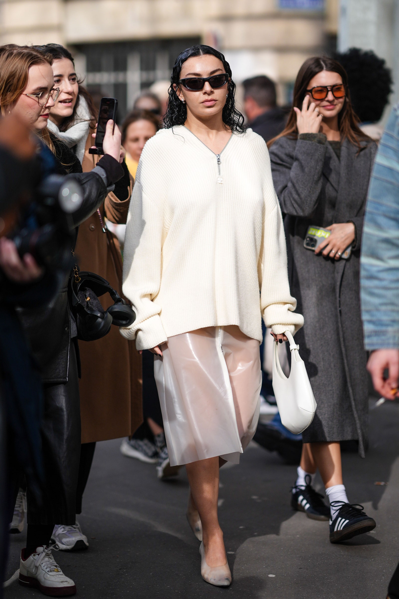 PARIS FRANCE FEBRUARY 28 Charli XCX wears a white wool pullover a midi skirt with transparent details white high heels...