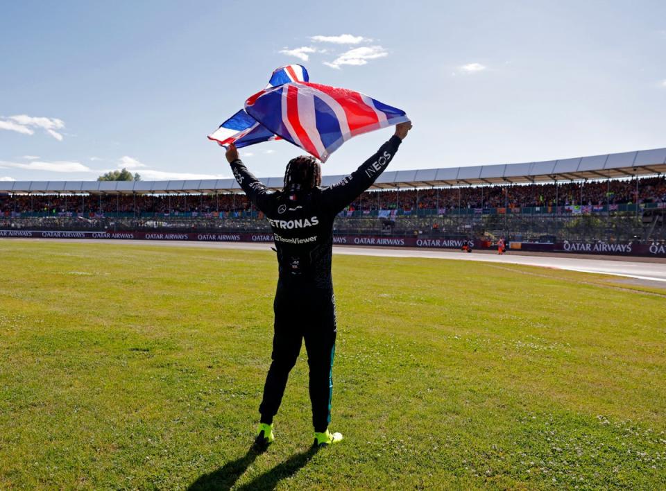 The Mercedes driver waved to the adoring crowd while holding a British flag (Reuters)