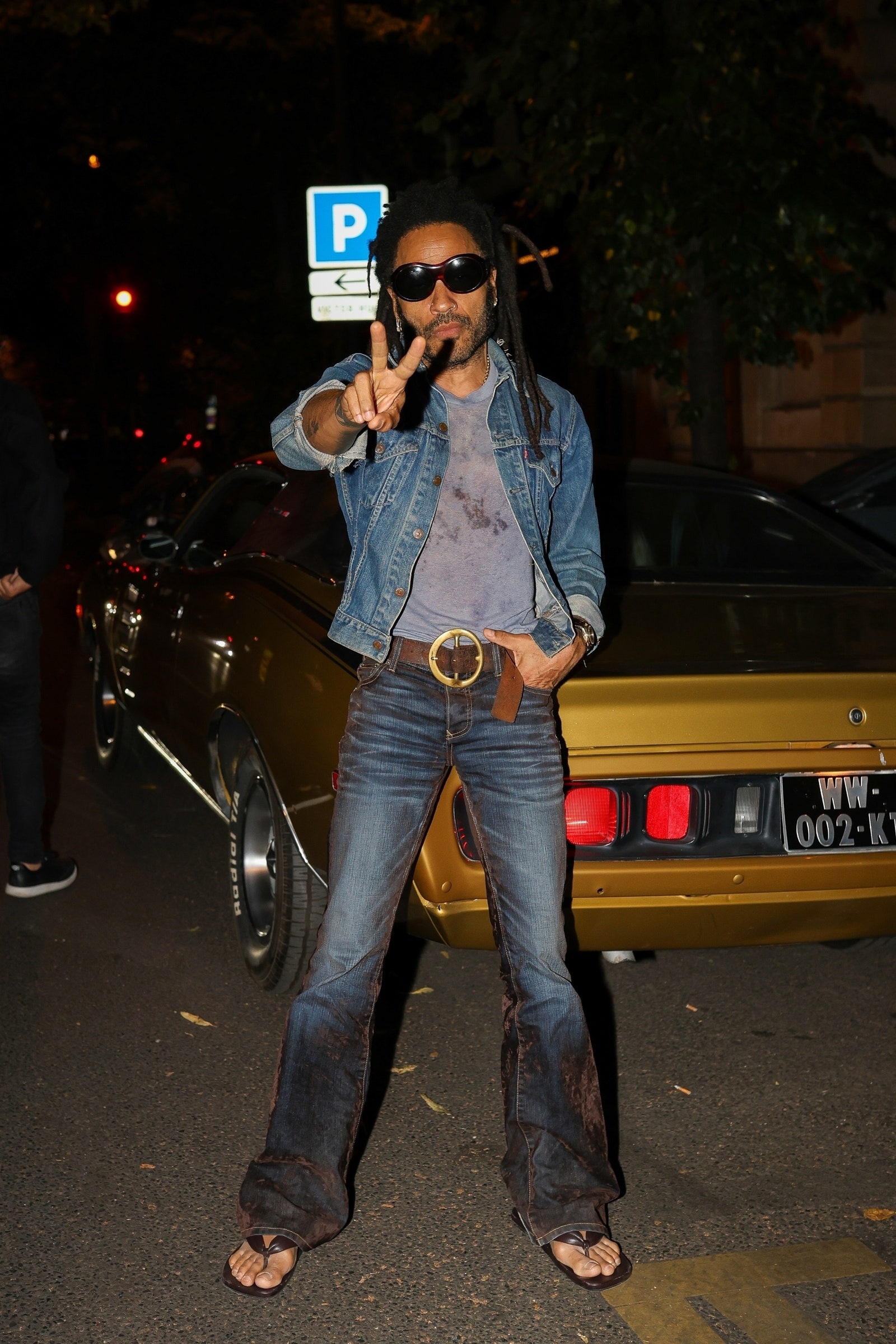 Paris FRANCE EXCLUSIVE Lenny Kravitz strikes a pose in front of his stunning goldyellow classic car in Paris casually...