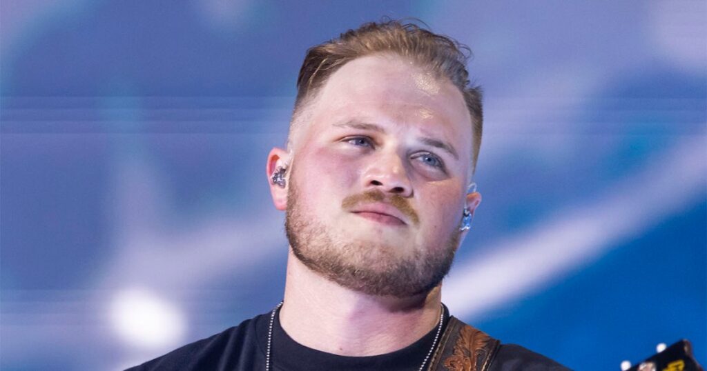 Zach Bryan Brings ‘Hawk Tuah’ Girl Onstage to Perform ‘Revival’ at Nashville Concert