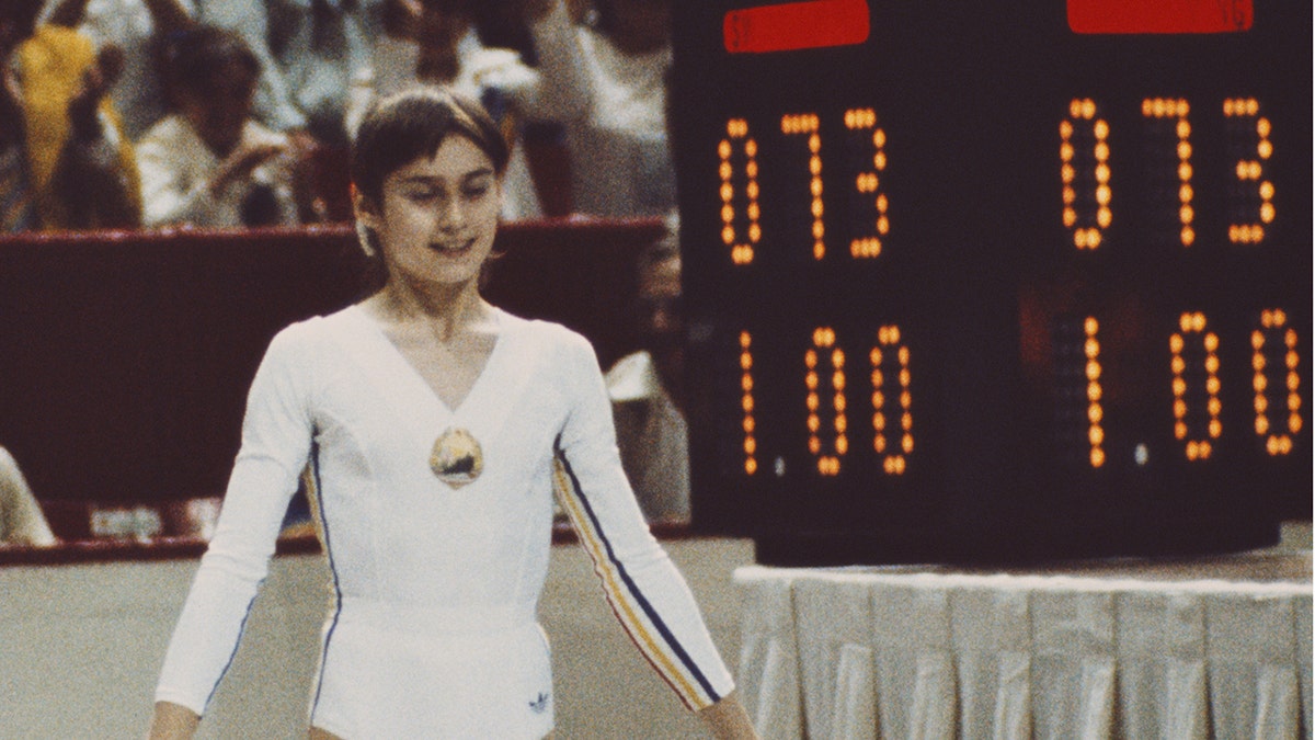 nadia standing by scoreboard reading 1.00
