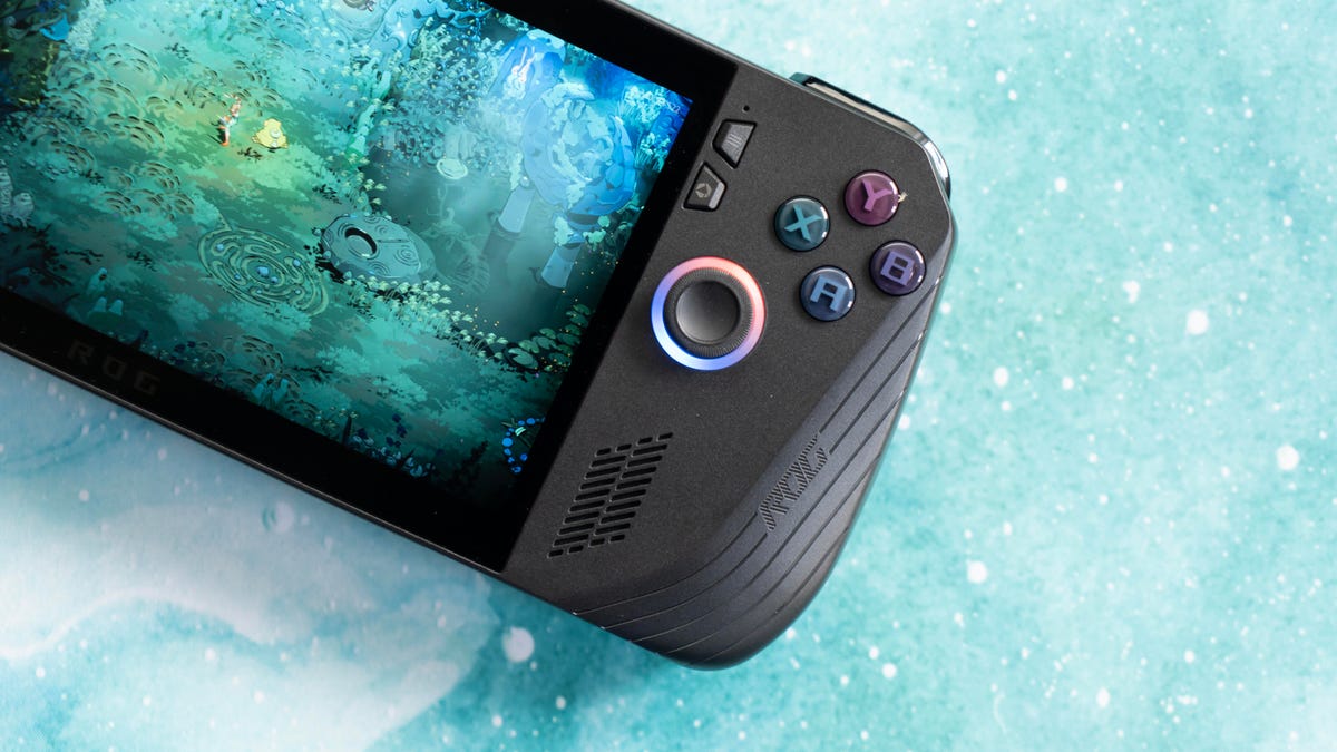 The Ally X angled with the screen facing up cropped in on the right grip, on a turquoise marbled background with a screen from Hades 2 on it