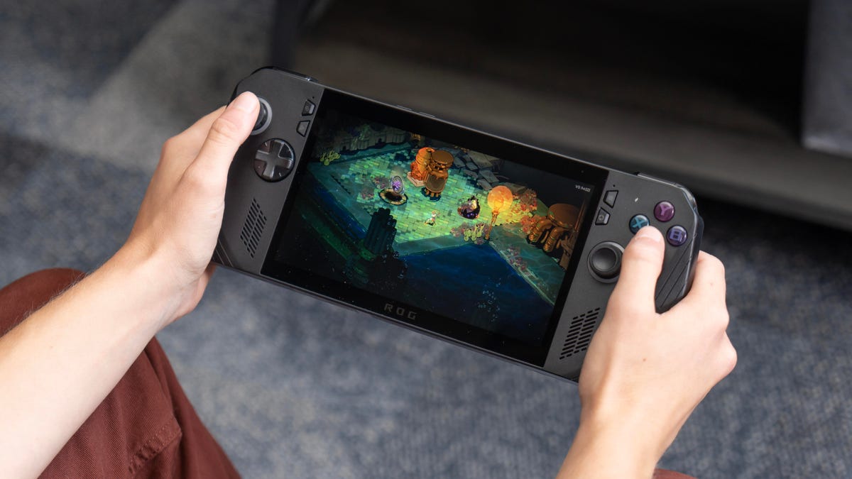 The Ally X in a woman's hands  with a screen from Hades 2 on it