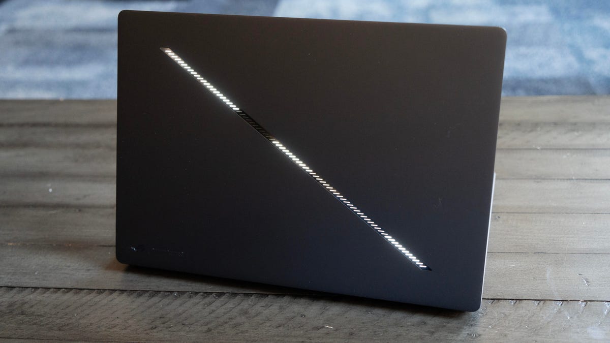 The cover of the laptop open and facing you showing the illuminated slash from top right to bottom left