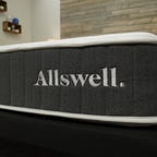 A close up of the affordable Allswell Hybrid mattress on top of a bed frame