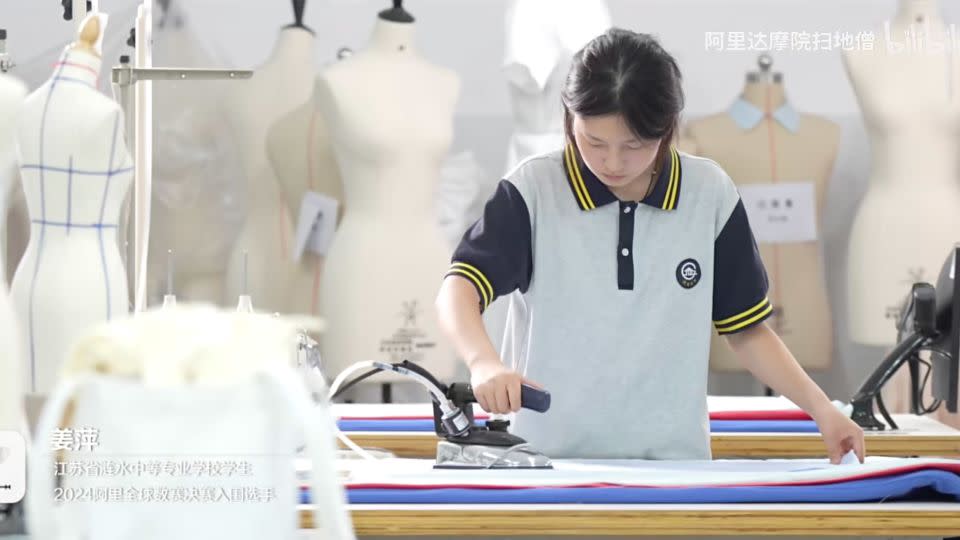 A screengrab from the documentary shows Jiang ironing clothes. - Alibaba Damo Academy Floor Sweeping Monk/Bilibili