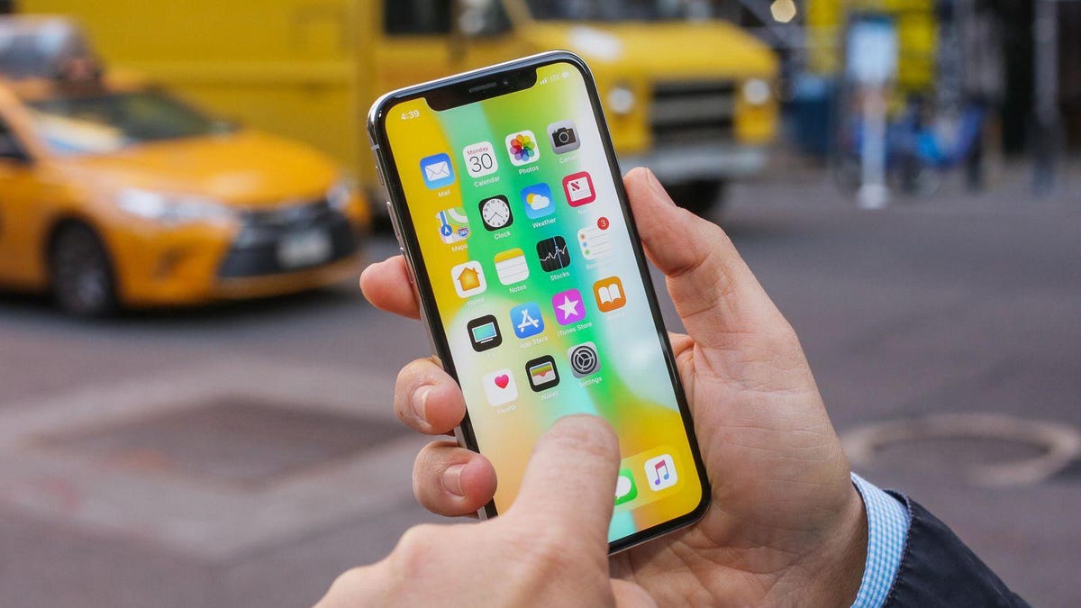 A person touching the screen of their iPhone