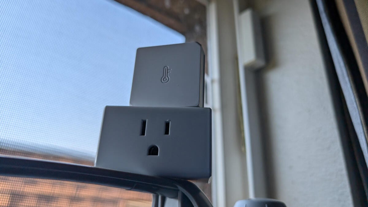 smart plug and smart home sensors resting on window fan