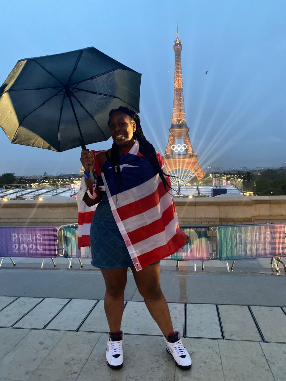 Manseen Logan standing in front of the Eiffel Tower during the Paris2024 Olympics.