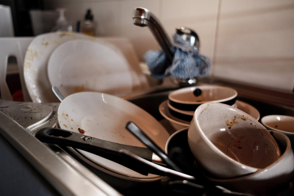 Sink filled with unwashed dishes, various bowls, and utensils