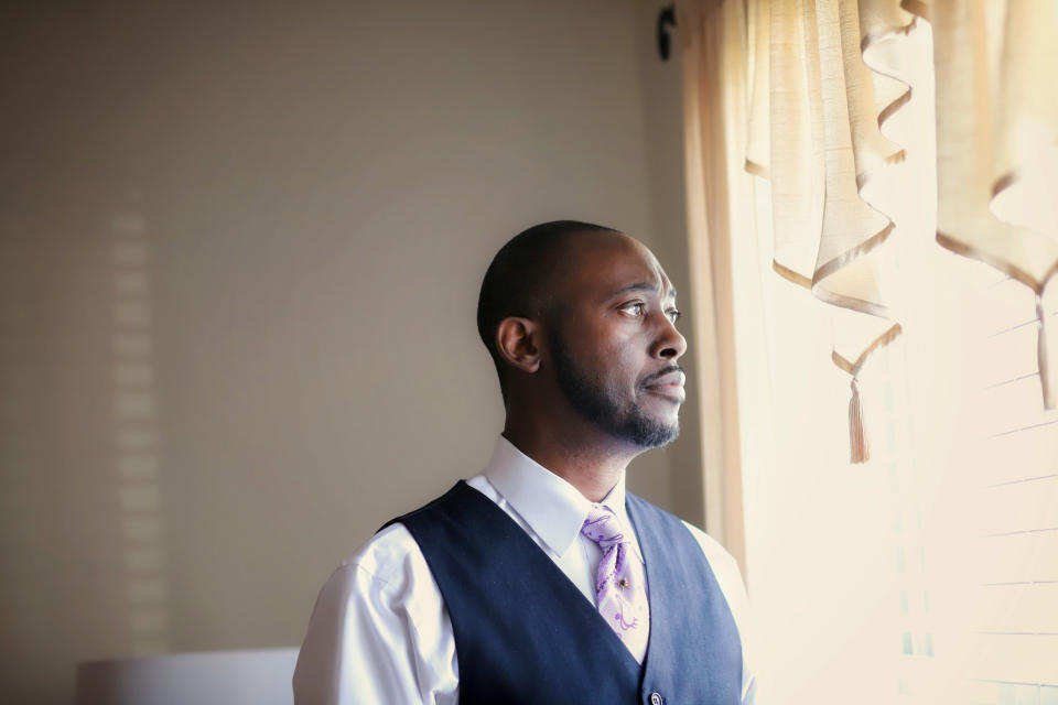 A man looking thoughtfully out a window