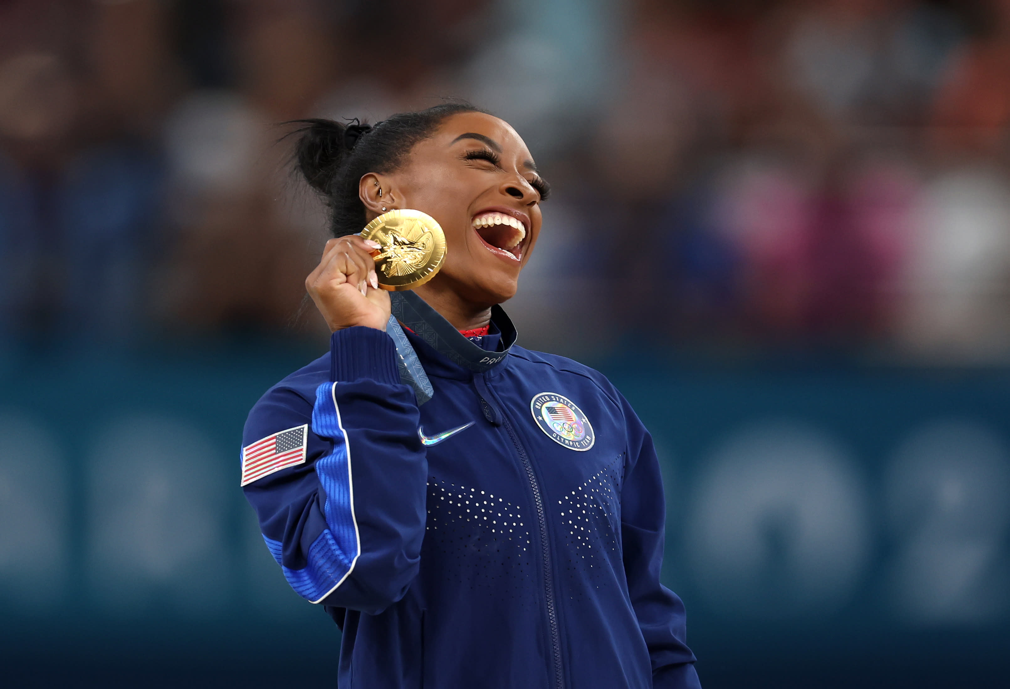 Gold medalist Simone Biles celebrates on the podium during the medal ceremony for the Artistic Gymnastics Women's Vault Final on day eight of the Olympic Games at Bercy Arena on August 03, 2024 in Paris, France. (Julian Finney/Getty Images)