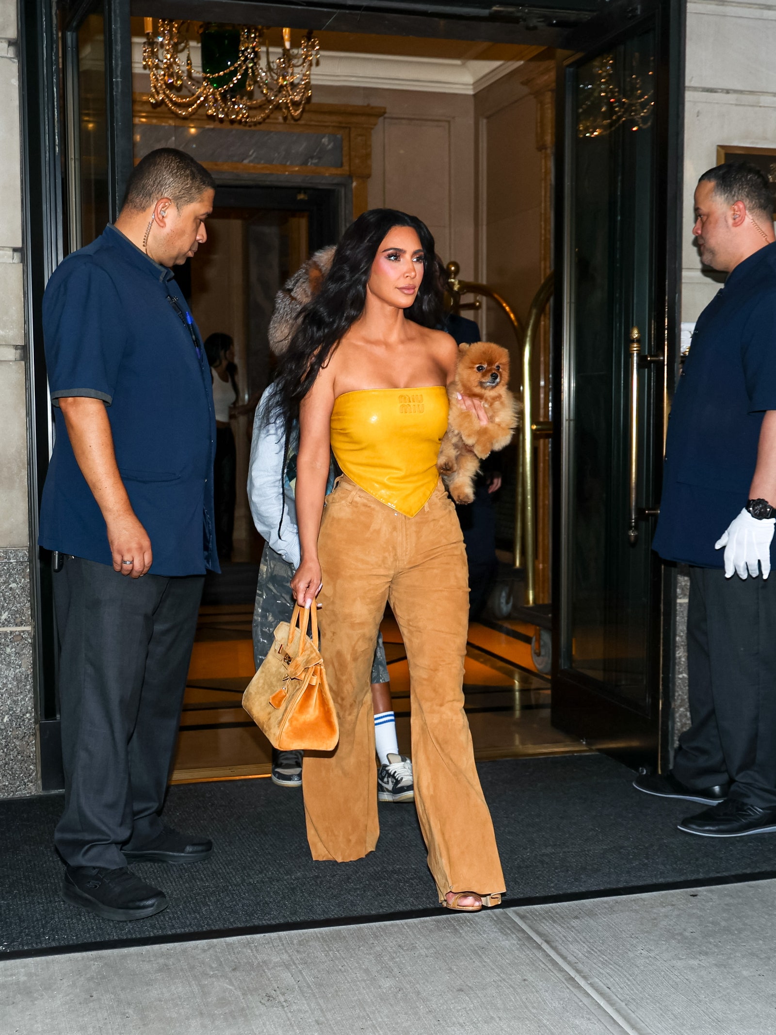 Image may contain Kim Kardashian Clothing Glove Pants Accessories Bag Handbag Toy Footwear Shoe Adult and Person