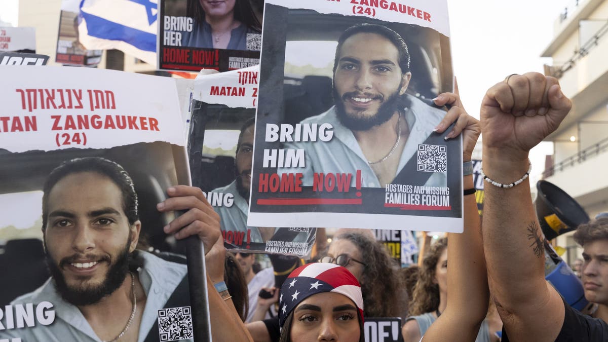 Families of hostages who were kidnaped by Hamas in the Oct. 7 deadly attack and supporters hold signs and U.S. flags during a demonstration outside a press event by U.S. Secretary of State Antony Blinken on August 19, 2024, in Tel Aviv, Israel.