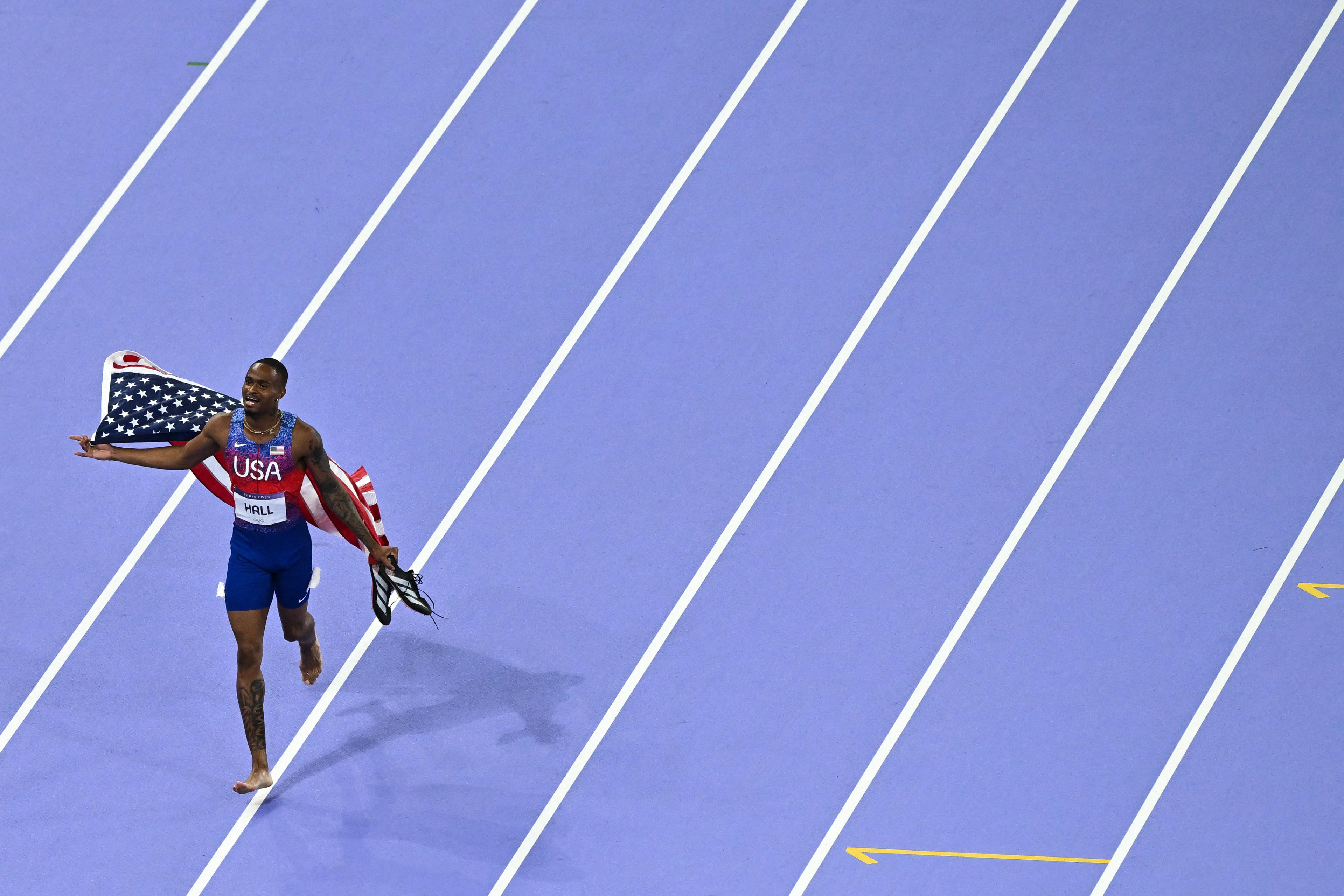 TOPSHOT - US' Quincy Hall celebrates after winning the men's 400m final of the athletics event at the Paris 2024 Olympic Games at Stade de France in Saint-Denis, north of Paris, on August 7, 2024. (Photo by Ben STANSALL / AFP) (Photo by BEN STANSALL/AFP via Getty Images)