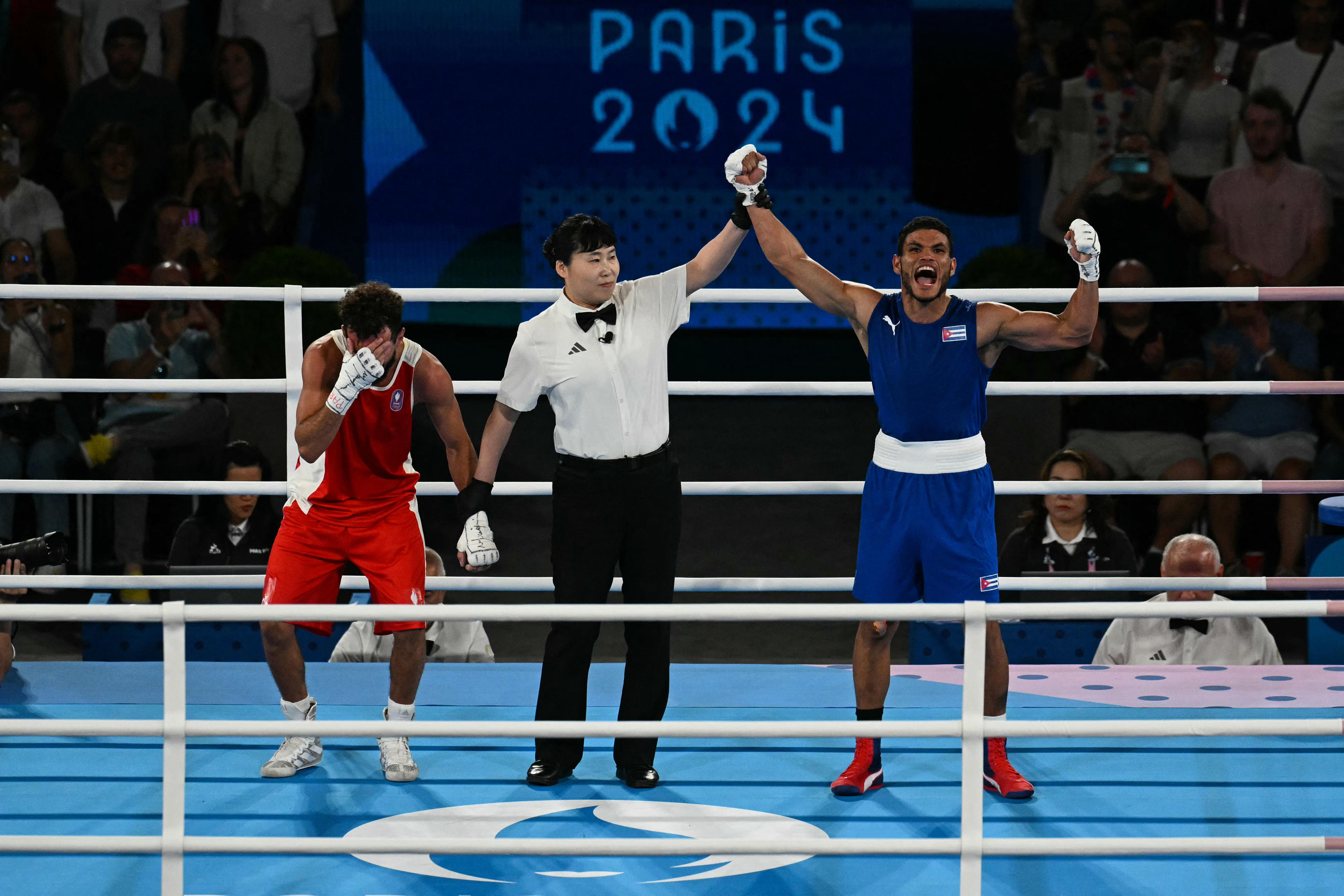 TOPSHOT - Cuba's Erislandy Alvarez (Blue) reacts after beating France's Sofiane Oumiha in the men's 63.5kg final boxing match during the Paris 2024 Olympic Games at the Roland-Garros Stadium, in Paris on August 7, 2024. (Photo by MOHD RASFAN / AFP) (Photo by MOHD RASFAN/AFP via Getty Images)