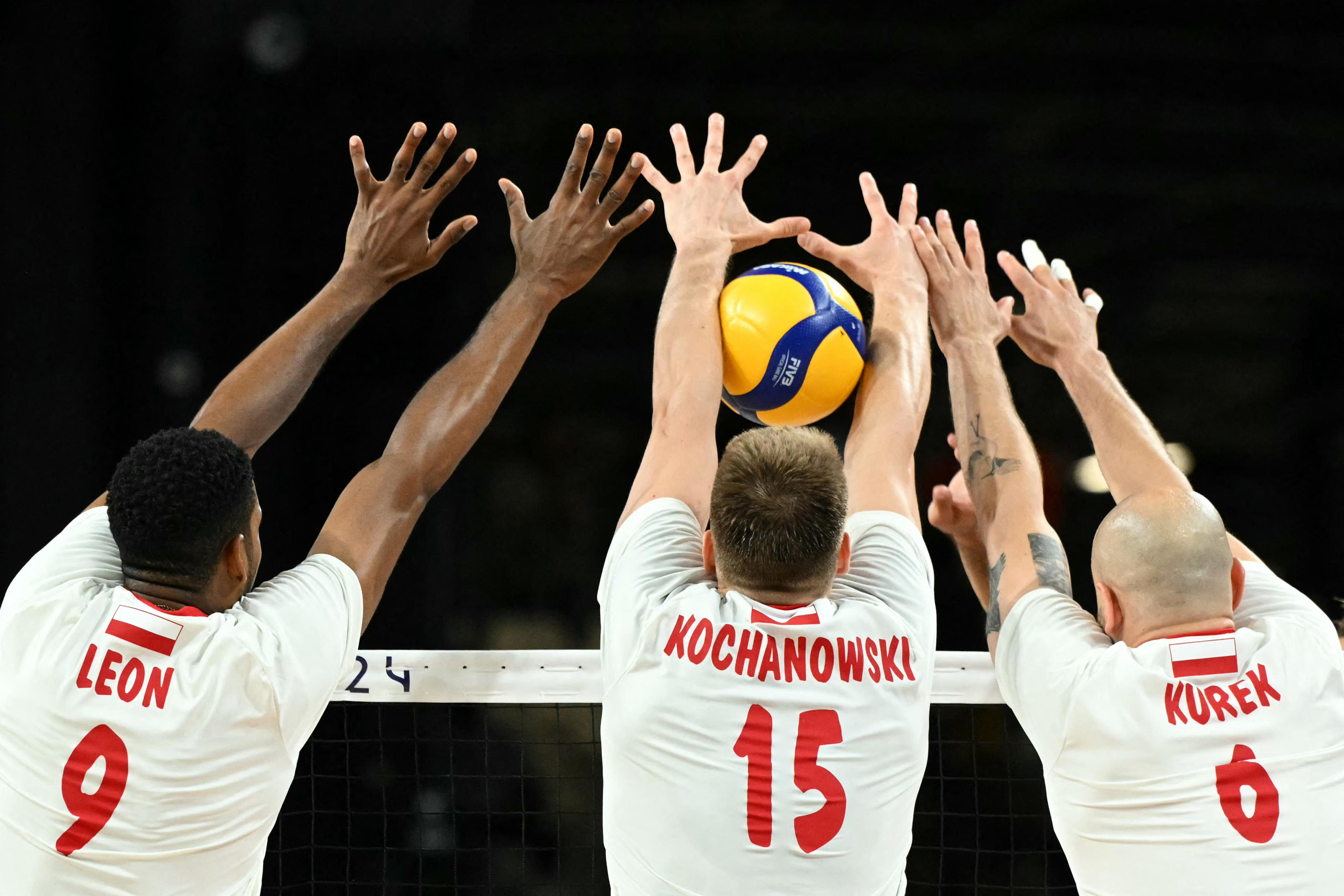 TOPSHOT - (L-R) Poland's #09 Wilfredo Leon Venero, Poland's #15 Jakub Kochanowski and Poland's #06 Bartosz Kurek block the ball during men's volleyball semi-final match between Poland and USA at the South Paris Arena 1 in Paris on August 7, 2024 during the Paris 2024 Olympic Games. (Photo by Natalia KOLESNIKOVA / AFP) (Photo by NATALIA KOLESNIKOVA/AFP via Getty Images)