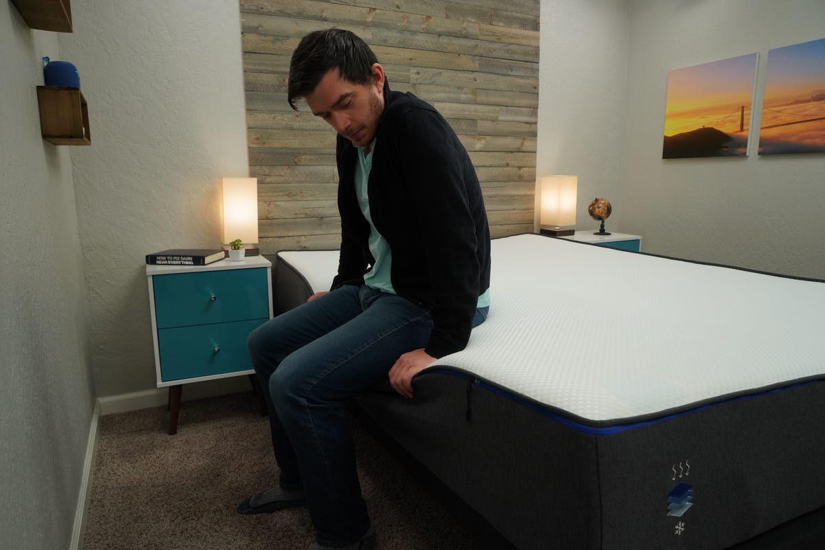 A sleep expert sitting on the edge of the Nectar mattress