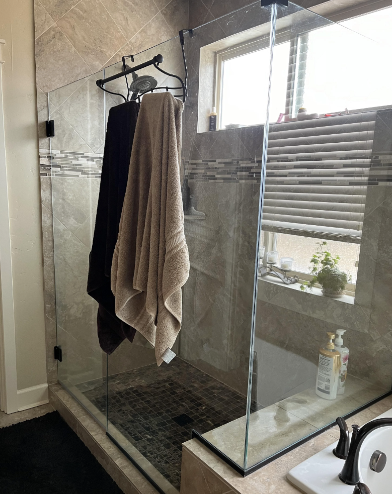 A Reddit post from the InteriorDesign subreddit discusses the pros and cons of elder glass shower doors. The image shows a bathroom with a glass shower door