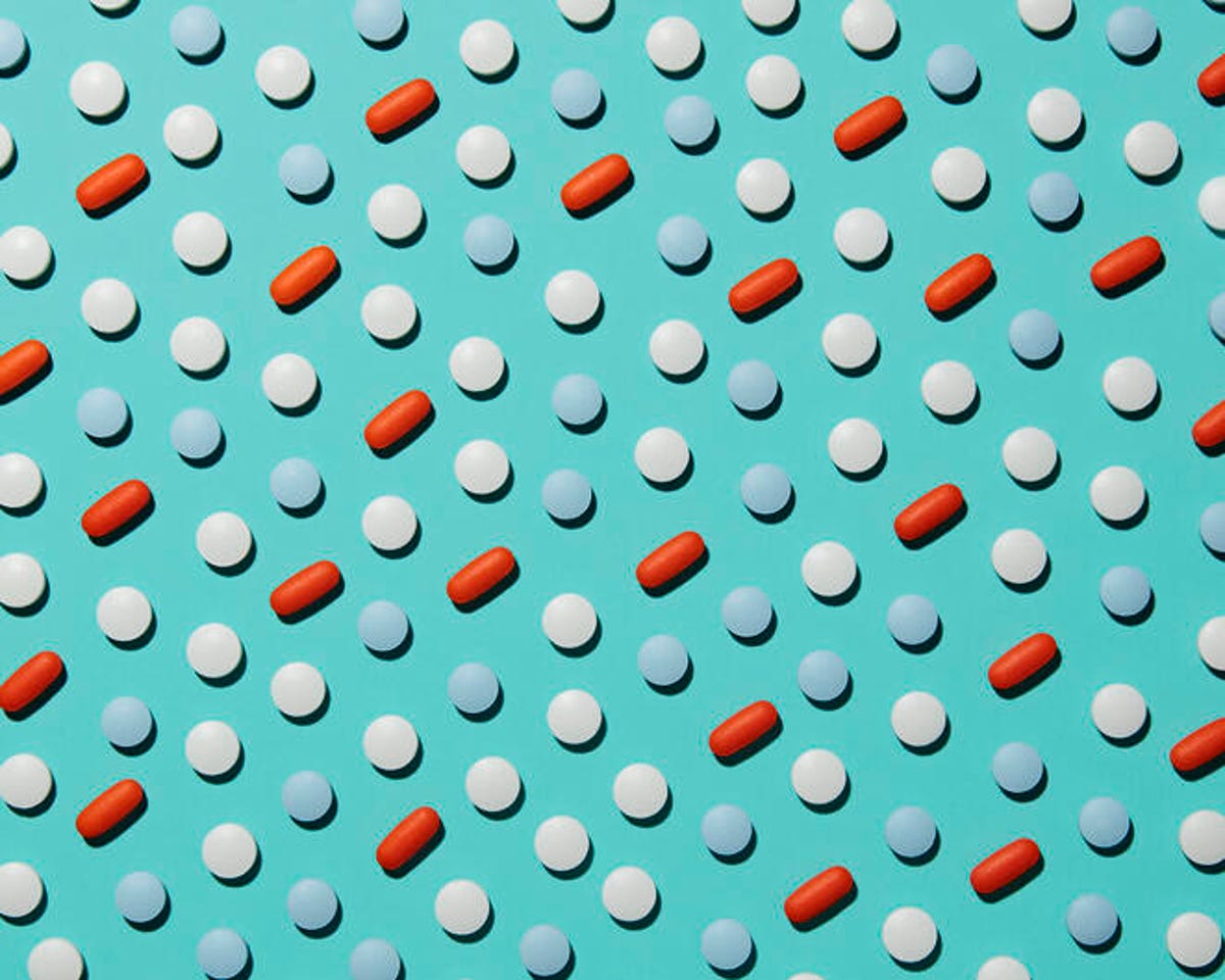 Blue, red and white pills laid out in a grid pattern on a blue background