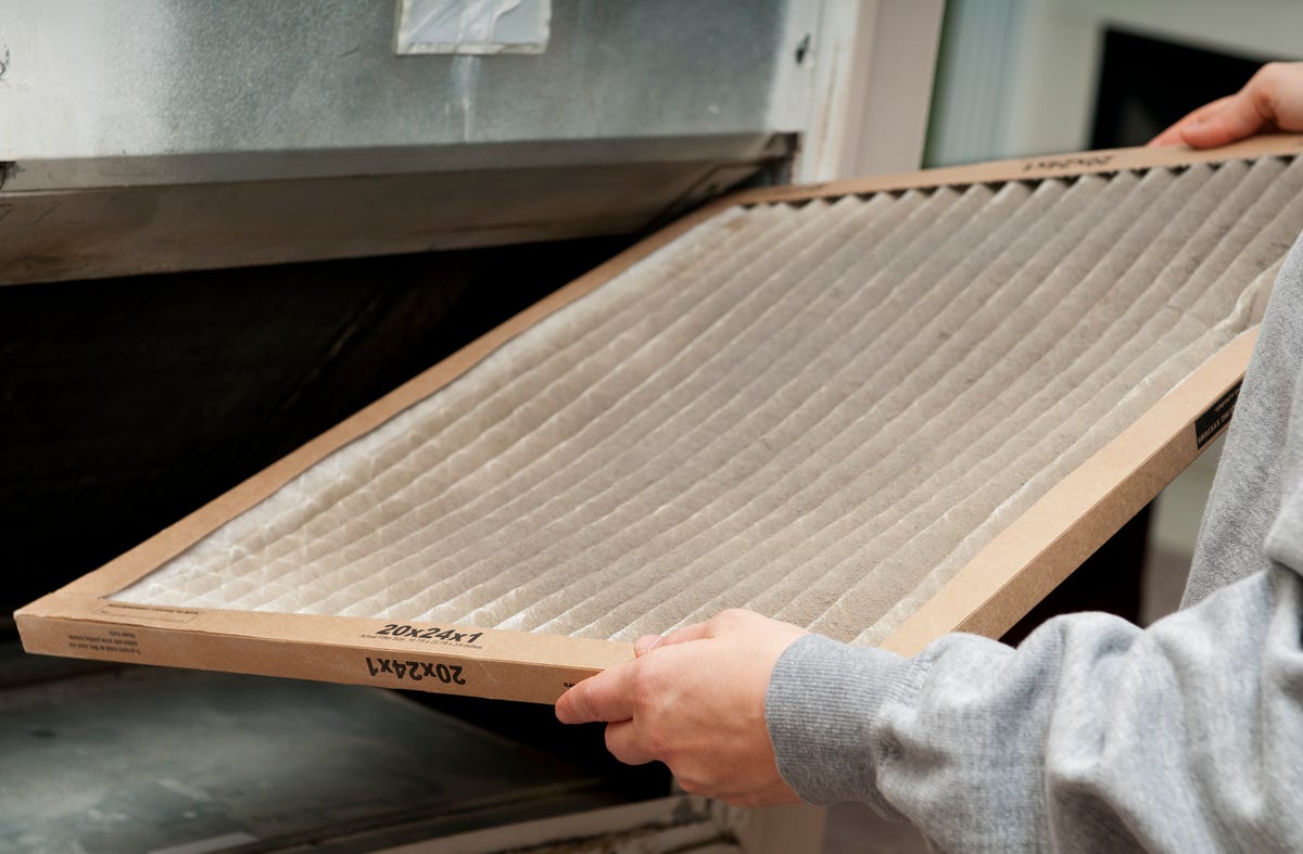 Home owner changing their dirty air filter.