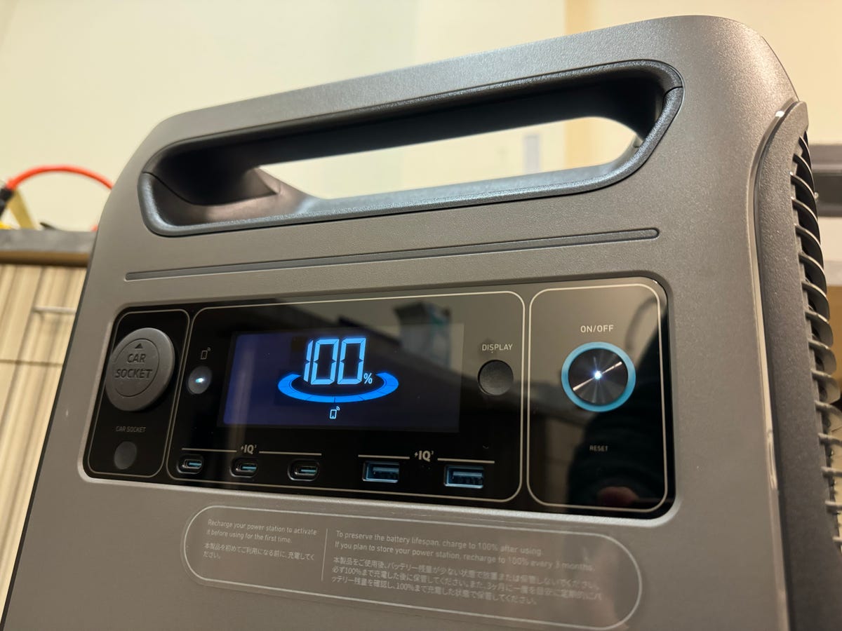 A portable power station's display reads that it's fully charged.