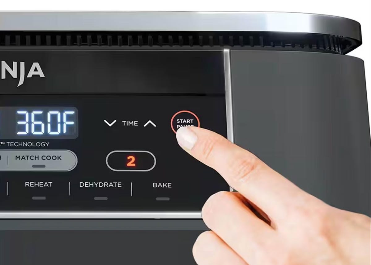 hand pushing ninja air fryer button