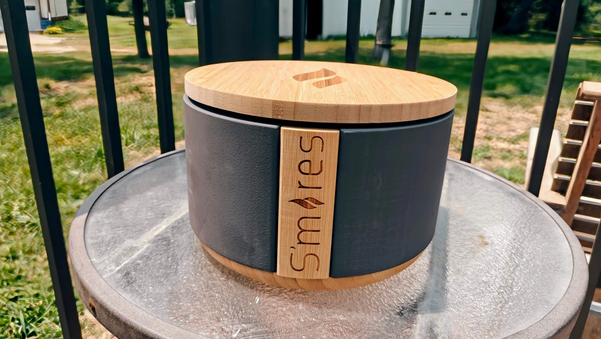 TerraFlame tabletop fire pit in grey sitting on a small table outdoors.