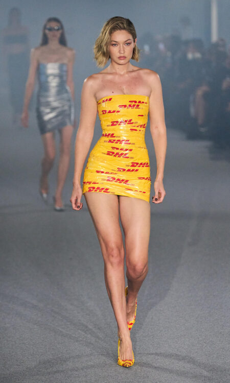 Gigi Hadid Turns Heads in DHL Tape Dress & Matching Pumps at Vetements Spring 2025 Show